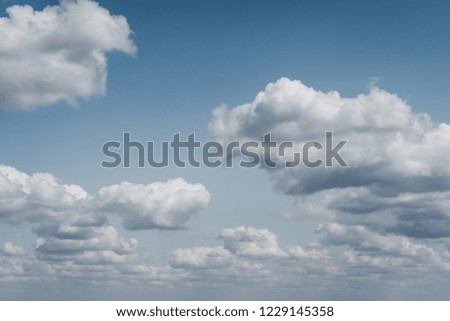Fluffy white clouds in a blue sky, conceptual.