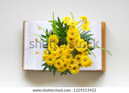 Open notebook with yellow flowers on top