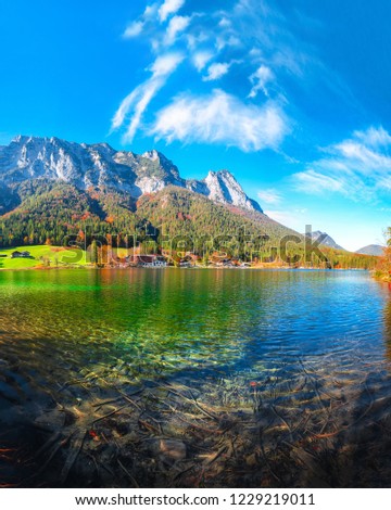 autumn sunny day on Hintersee lake. Beautiful scene of mirror reflection in water of Hintersee lake. Location: resort Ramsau, National park Berchtesgadener Land, Upper Bavaria, Germany Alps, Europe