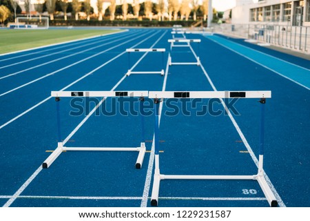 Hurdles on running track front view, nobody on it. Royalty-Free Stock Photo #1229231587