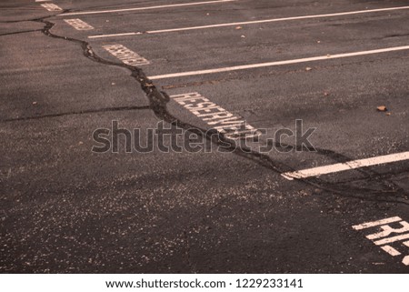 Reserved parking written signs right on the dark cracked asphalt 