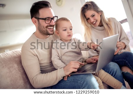 Happy family using technology  together in living room. 