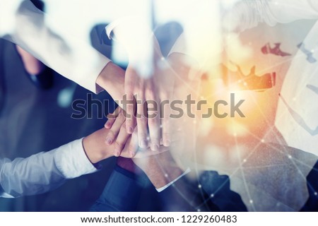 Business people putting their hands together. Concept of startup, integration, teamwork and partnership. Double exposure Royalty-Free Stock Photo #1229260483