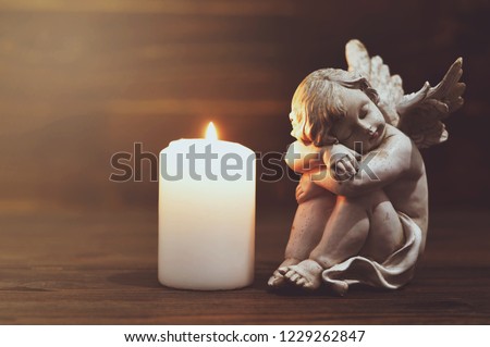 Angel and white burning candle   Royalty-Free Stock Photo #1229262847