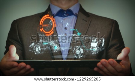 A futuristic portrait man is holding a digital tablet, which a hologram is a graphic layout that is being designed by a virtual machine (the car of the future). Concept from: Hologram, Future.