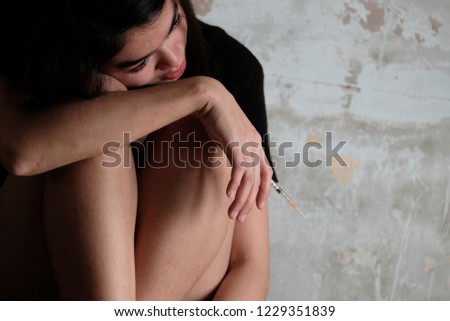 Depressed woman sitting on ground, female in depression sadness on old concrete background