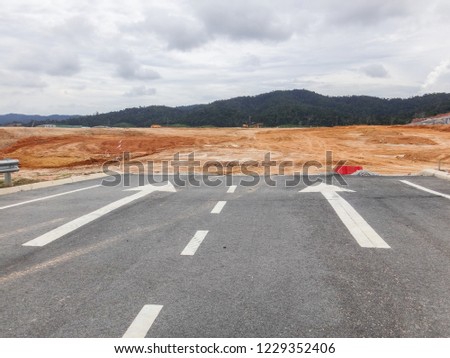 White painting direction arrow symbol on black asphalt road background. Road marking on road. Arrow on the road markings. 