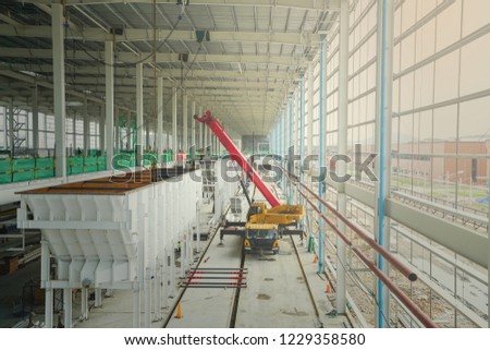 Steel structure roof truss with metal roof sheet installation by mobile crane under the construction building in the factory with blue sky