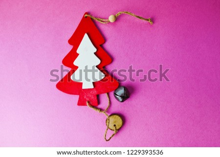 Festive Christmas winter winter happy beautiful pink purple background with a small toy wooden homemade cute Christmas tree. Flat lay. Top view. Holiday decorations.