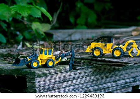 Two bulldozers on old wooden planks.
