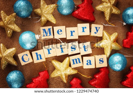 Vivid Merry Christmas festive greeting image with a text on wooden cubes and bright colorful toys