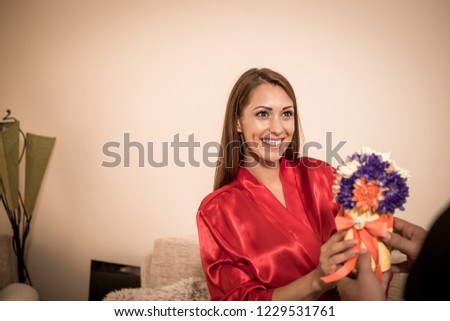 A beautiful brunette gets a bunch of flowers from a man.