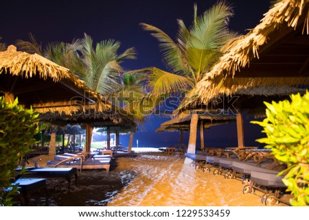 Sun loungers and parasols on a sandy beach, evening romantic atmosphere by the sea. Relax on the paradise.
