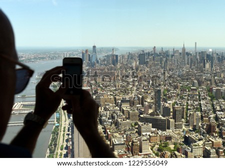 Man make a pictures on smartphone of the New York cityscape. Top view on the New York.
