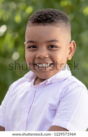 Adorable latin child in the garden with a beautiful green of background