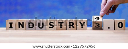 Hand is turning a dice and changes the word "Industry 3.0" to "Industry 4.0" Royalty-Free Stock Photo #1229572456