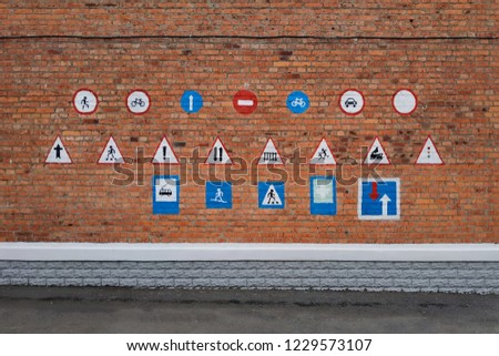 traffic signs on a brick wall of a school. The concept of child safety, education, training warning signs.