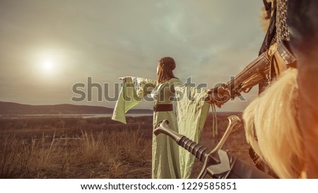 Medieval knight with lady on the sunset background.