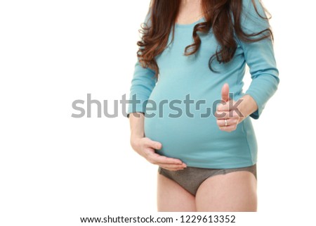 pregnant woman wearing blue shirt with gray panties with thumbs up gesture