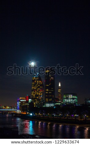 Beautiful night panoramic skyline view of Bank central London's leading financial districts and Thames river with full moon and clouds