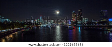 Beautiful night panoramic skyline view of Bank central London's leading financial districts and Thames river with full moon and clouds