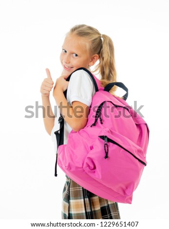 Pretty cute blonde hair girl with a pink schoolbag looking at camera showing thumb up gesture happy to go to school isolated on white background in back to school and children education concept.