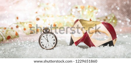 Carnival party countdown. Minutes to midnight on an old watch, colorful mask, bokeh festive background, banner