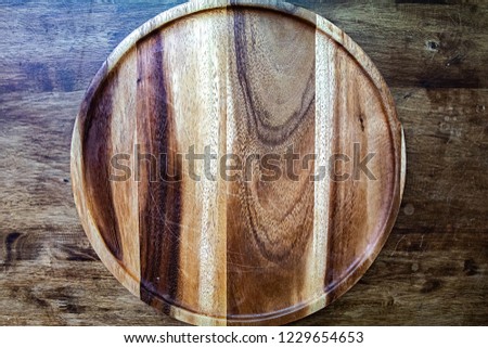 Wooden round empty board for pizza on wood table background, top view. Mockup for menu, recipe or any dish. Vertical image