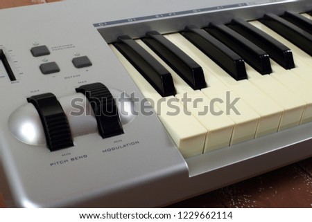 Musical instrument - Sloseup fragment MIDI piano 61 key keyboard on a wooden background