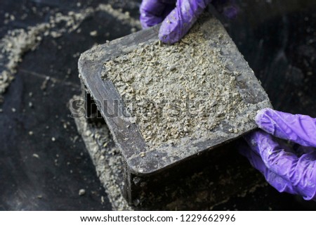 Picture of fresh mix of hempcrete (hemp concrete) being cast into a cube mould.