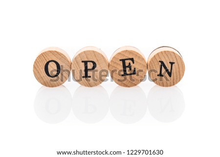 Word Open from circular wooden tiles with letters children toy. Concept of working hours spelled in children toy letters.