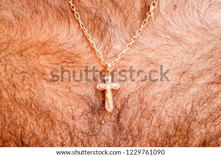 golden cross with a chain on a hairy chest
