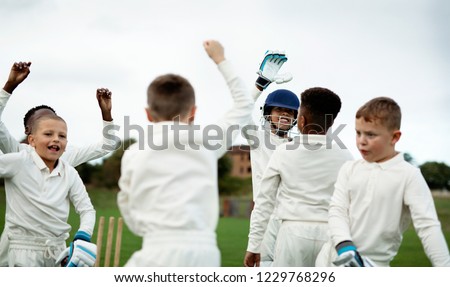 Young happy cricketers cheering on the field