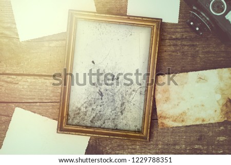 Retro black and white picture with blank rustic photos on wooden desk, memory space