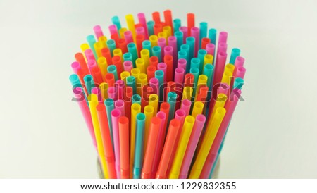 Colorful plastic drinking straws held together against a neutral background. One use, made of plastic straws, number one reason of oceans pollution, harming marine, difficult to biodegrade or dissolve