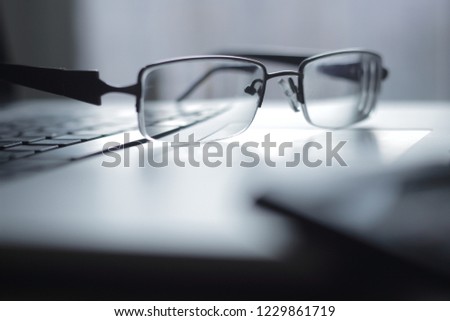close up.glasses in black frame on the laptop keyboard.photo wit