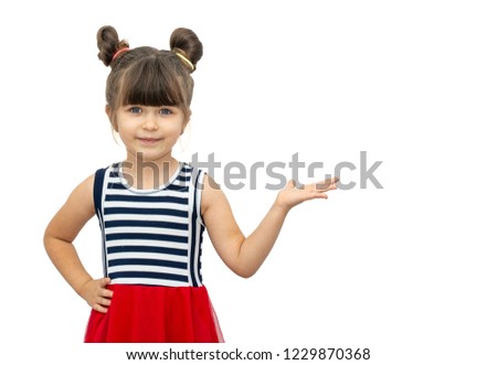 Portrait of joyful child posing and smiling with funny haircut, pointing at free space for advertisement. Copy space, isolated