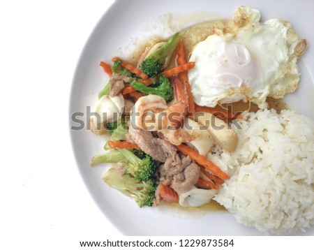 Mixed vegetable stir-fried with shrimp, pork and chicken with rice and fried egg in white plate. Vegetarian or healthy food concept. Favorite Chinese main dish recipes. vintage filter.