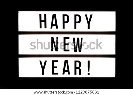Happy New Year! text in a light box, isolated over a black background.