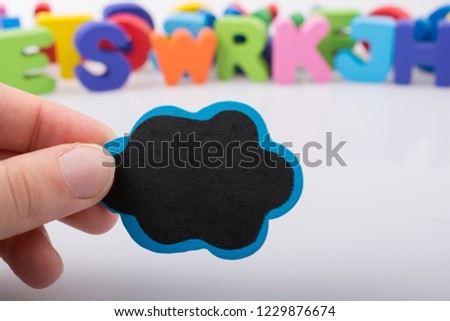 Speech bubble in hand with colorful letters behind