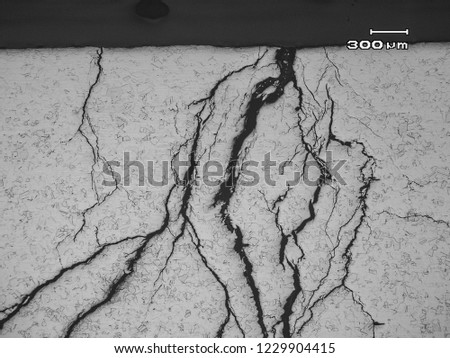 Micrograph of stress corrosion cracking in austenitic stainless steel type 304. They were branchy and transgranular caused by contact to Chloride ions and residual tensile stress in the steel. Royalty-Free Stock Photo #1229904415