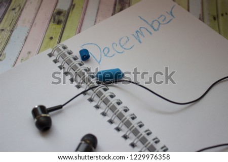 Notepad for sketches next to headphones on a colored background