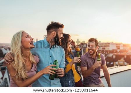 Cropped shot of four friends hanging out on a rooftop Royalty-Free Stock Photo #1230011644