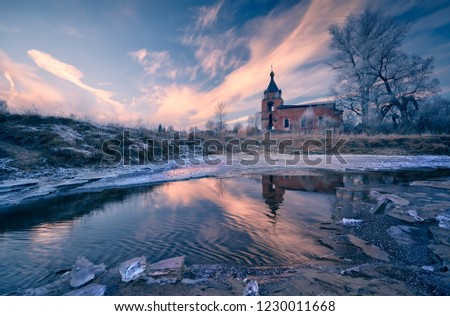 Picture of a cold November day with a frozen river and a church on the shore