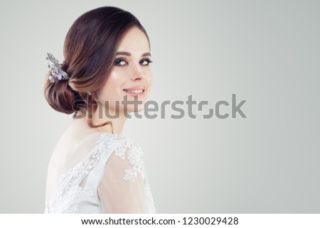 Charming young woman bride with makeup and bridal hairstyle. Pretty woman fiancee on white background with copy space, face closeup