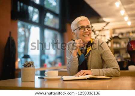 Woman in a coffee shop drinks coffee and thinks about the business.