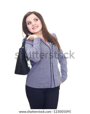 Attractive young woman in a gray blouse keeps behind the back a black handbag and looks into upper-left corner. Isolated on white background