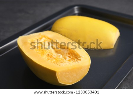 Baking tray with cut spaghetti squash on table