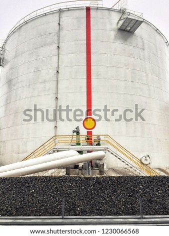 big white vertical fuel tank with pipes