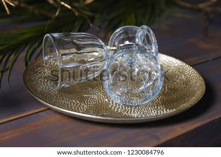 New Year holiday decorated table with golden plate. Vintage wine glasses on the vintage blue table with Christmas tree.
